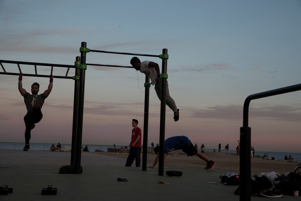 People exercise at a public gym by the beach in Barcelona, Spain, March 28, 2018. REUTERS/Susana Vera - RC1D245CD4C0