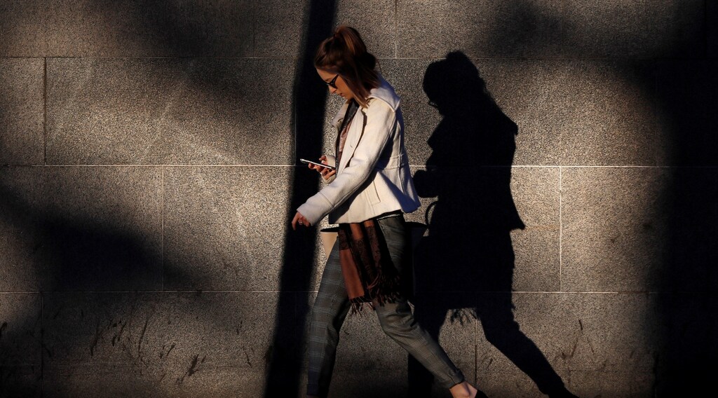 A woman looks at her mobile phone early morning in Westminster, London, Britain October 10, 2016.