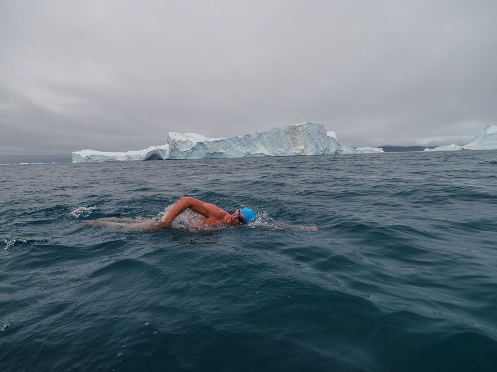 Lewis Pugh is pictured swimming past an iceberg, as part of his series of extreme swims to raise awareness of climate change.