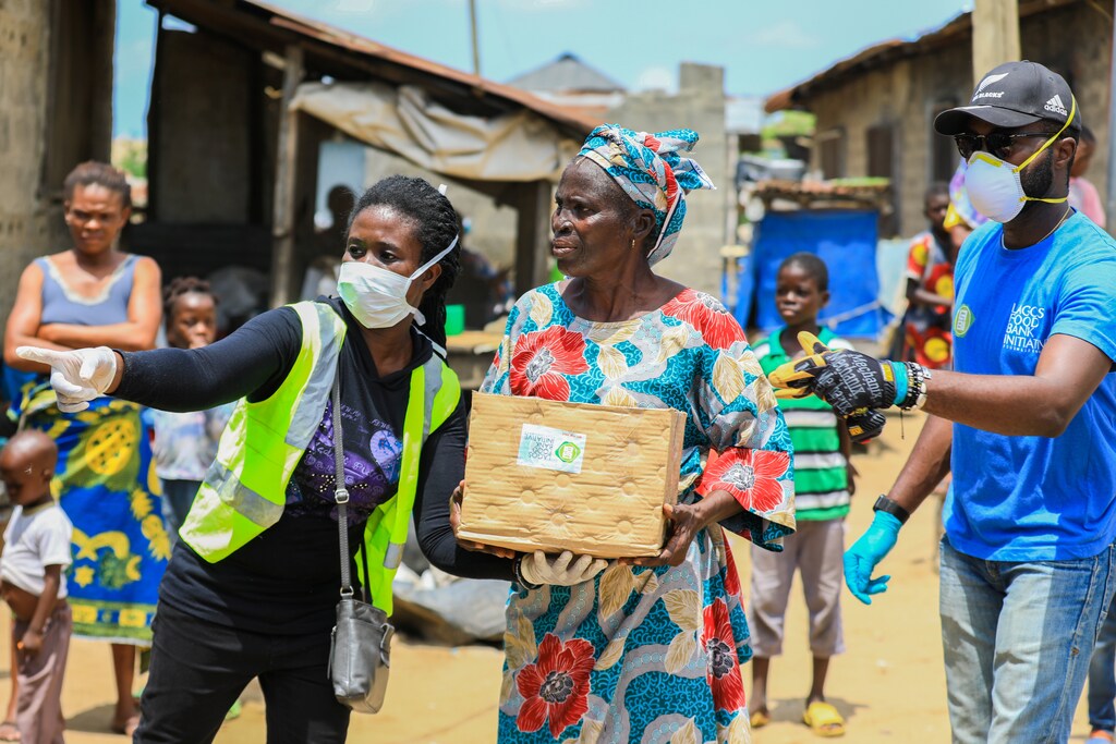 Volunteers gesture as they direct an elderly woman at an ongoing distribution of food parcels, during a lockdown by the authories in efforts to slow the spread of the coronavirus disease (COVID-19), in Lagos, Nigeria April 9, 2020. Picture taken April 9, 2020. REUTERS/Temilade Ade - RC2L5G9T8QZW
