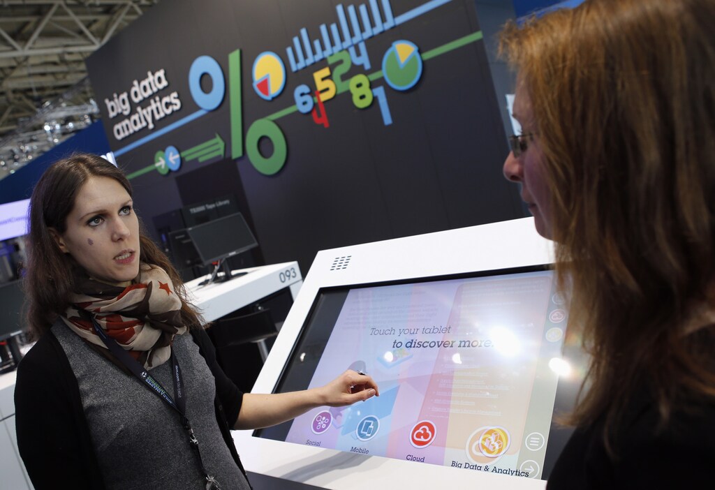 An exhibitor explains the usage of big data analytics at the booth of IBM during preparations for the CeBIT trade fair in Hanover, March 9, 2014. The world's biggest computer and software fair will be open to the public from March 10 to 14. REUTERS/Fabrizio Bensch (GERMANY - Tags: BUSINESS TELECOMS SCIENCE TECHNOLOGY) - RTR3GAYP
