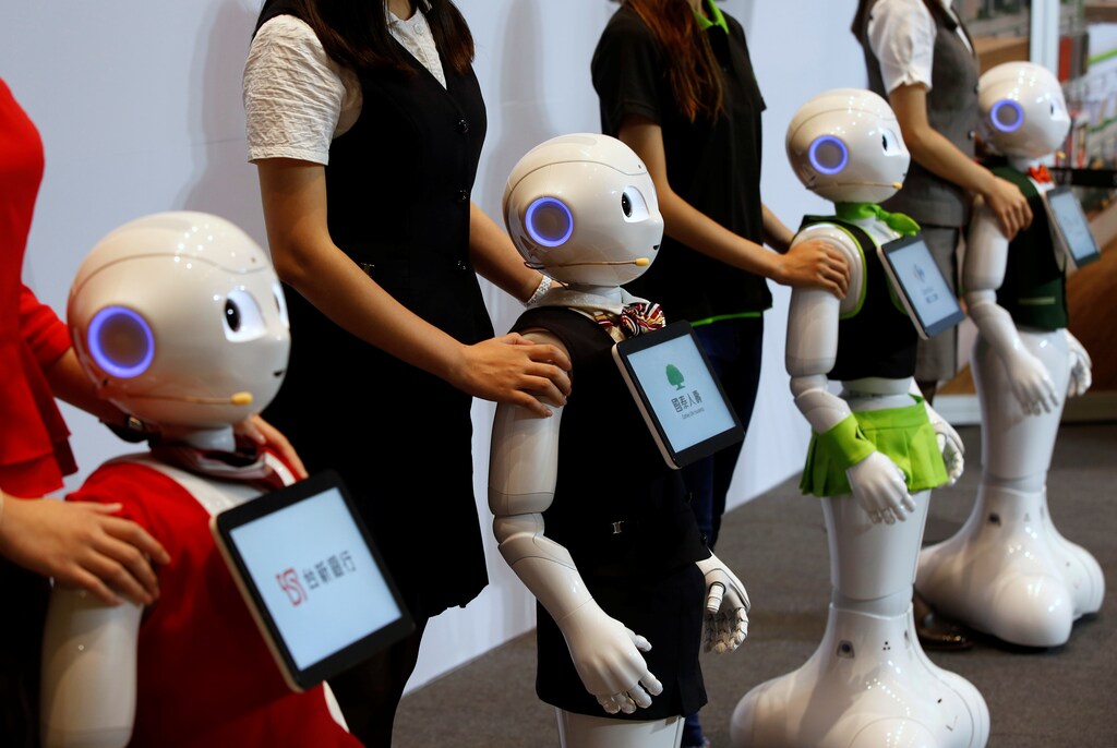 SoftBank's robots 'pepper', dressed in different bank uniforms, are displayed during a news conference in Taipei, Taiwan July 25, 2016. REUTERS/Tyrone Siu - D1BETROXIJAA
