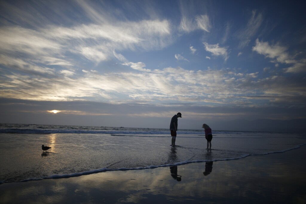 A man and a girl paddle in the Pacific Ocean at sunset in Santa Monica, California February 5, 2015.