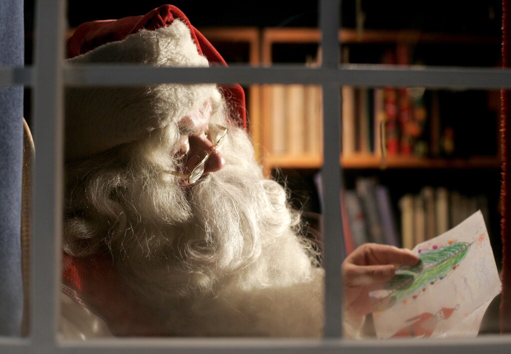 A man dressed as Santa Claus reads letters from children from around the world in his office at the Santa Claus' Village at the Arctic Circle near Rovaniemi, Finland. Picture taken December 18, 2007. REUTERS/Kacper Pempel(FINLAND) - GM1DWVTLDAAA