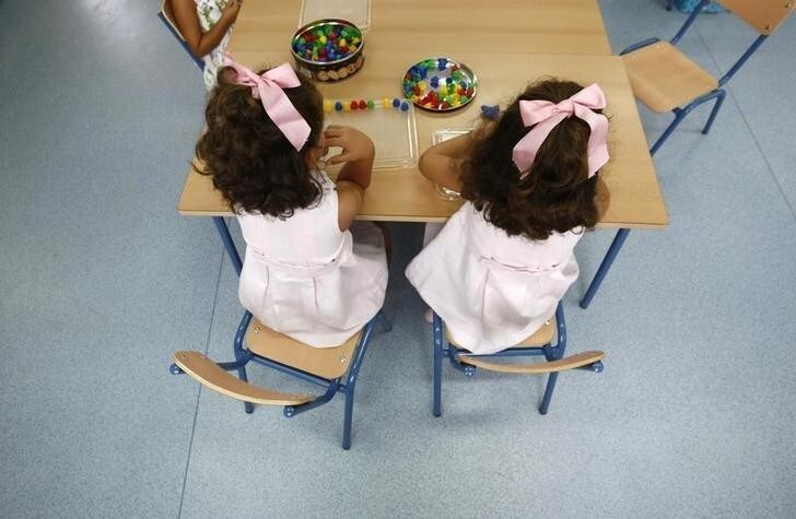 A pair of twins sit in a classroom on the first day of classes in an elementary school in the Andalusian capital of Seville, southern Spain September 10, 2009. REUTERS/Marcelo del Pozo (SPAIN EDUCATION IMAGES OF THE DAY SOCIETY)