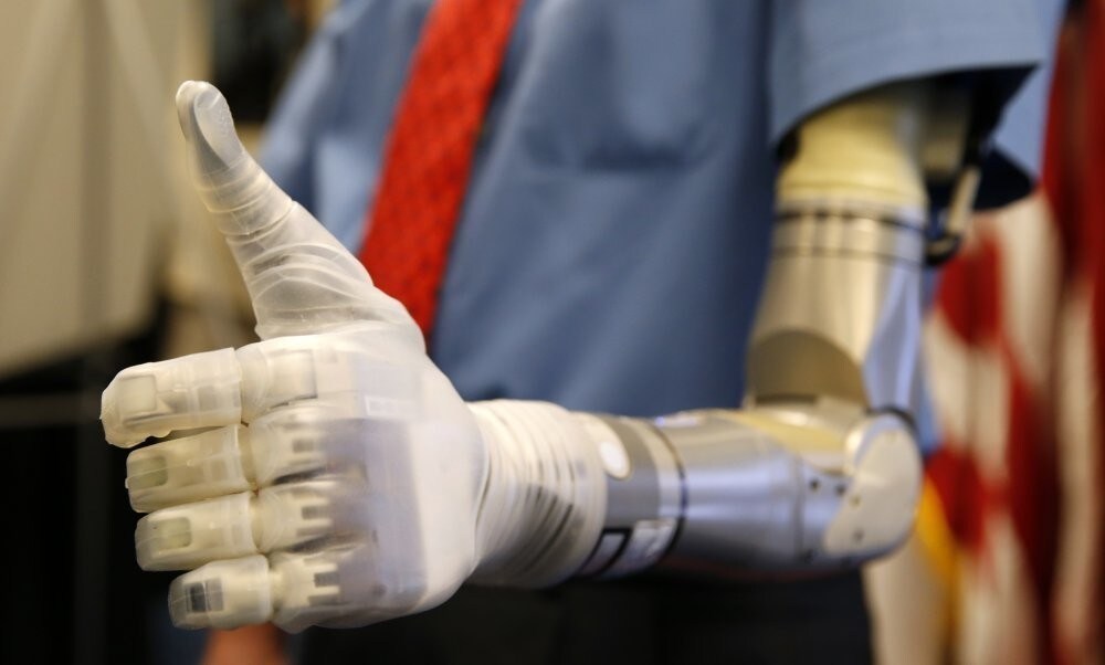 Vietnam veteran Fred Downs gives a thumbs up during a demonstration of modular prosthetic arm technology developed by the Defense Advanced Research Projects Agency (DARPA) at the Pentagon in Washington April 22, 2014.
