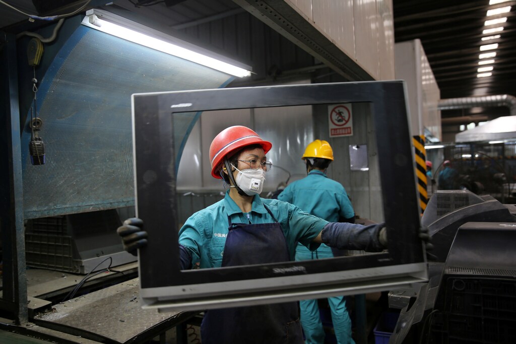 Workers dismantle used television sets at a recycling plant in Neijiang, Sichuan province, China June 11, 2018. REUTERS/Stringer