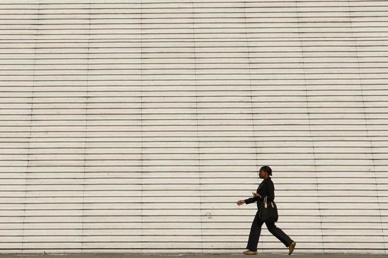 A businesswoman walks past the steps at the Arche de la Defense, the financial and business district west of Paris, August 5, 2009. REUTERS/Benoit Tessier (FRANCE BUSINESS) - PM1E585199001