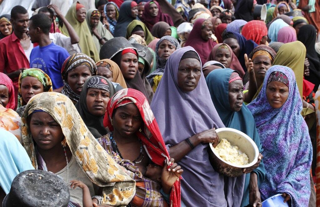 Internally displaced Somali women wait for food at a camp in the capital Mogadishu, July 20, 2011. The United Nations on Wednesday declared famine in two regions of southern Somalia, and warned that this could spread further within two months in the war-ravaged Horn of Africa country unless donors step in. REUTERS/Omar Faruk (SOMALIA - Tags: DISASTER SOCIETY CONFLICT) TEMPLATE OUT - RTR2P2Z8