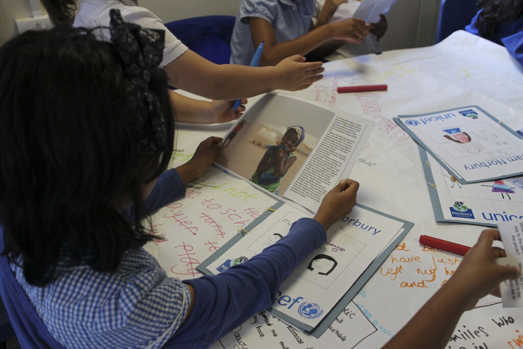 Primary school children, including those with refugee backgrounds, read real-life stories about refugees during a classroom lesson about the refugee crisis at Norbury School in Harrow, London, Britain July 15, 2016. Picture taken July 15, 2016. Thomson Reuters Foundation/Lin Taylor - RTSIU5X