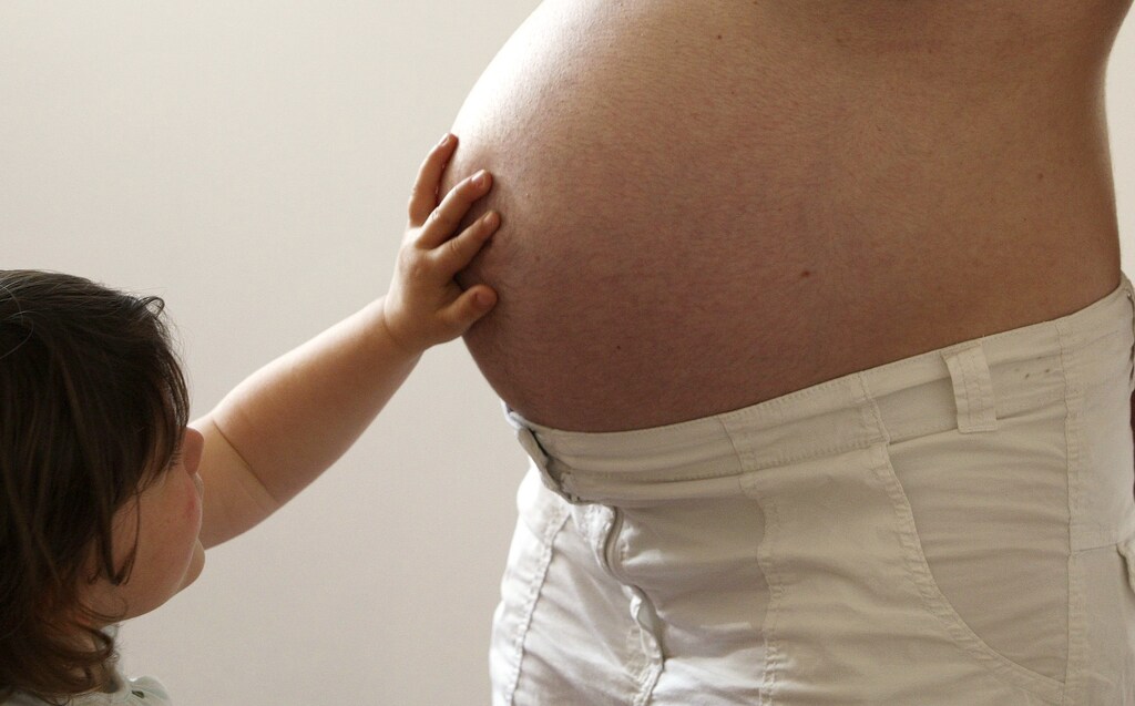 A child touches her pregnant mother's stomach at the last stages of her pregnancy in Bordeaux April 28, 2010. A January 2010 report indicates that life expectancy and fertility of French women are among the highest in Europe. REUTERS/Regis Duvignau (FRANCE - Tags: SOCIETY HEALTH) - RTR2DBMQ