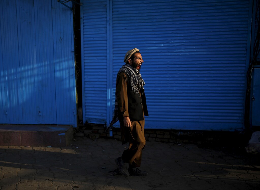 An Afghan man yawns as he walks at a market in the early morning hours in Kabul, Afghanistan July 30, 2015. REUTERS/Ahmad Masood - GF20000008449