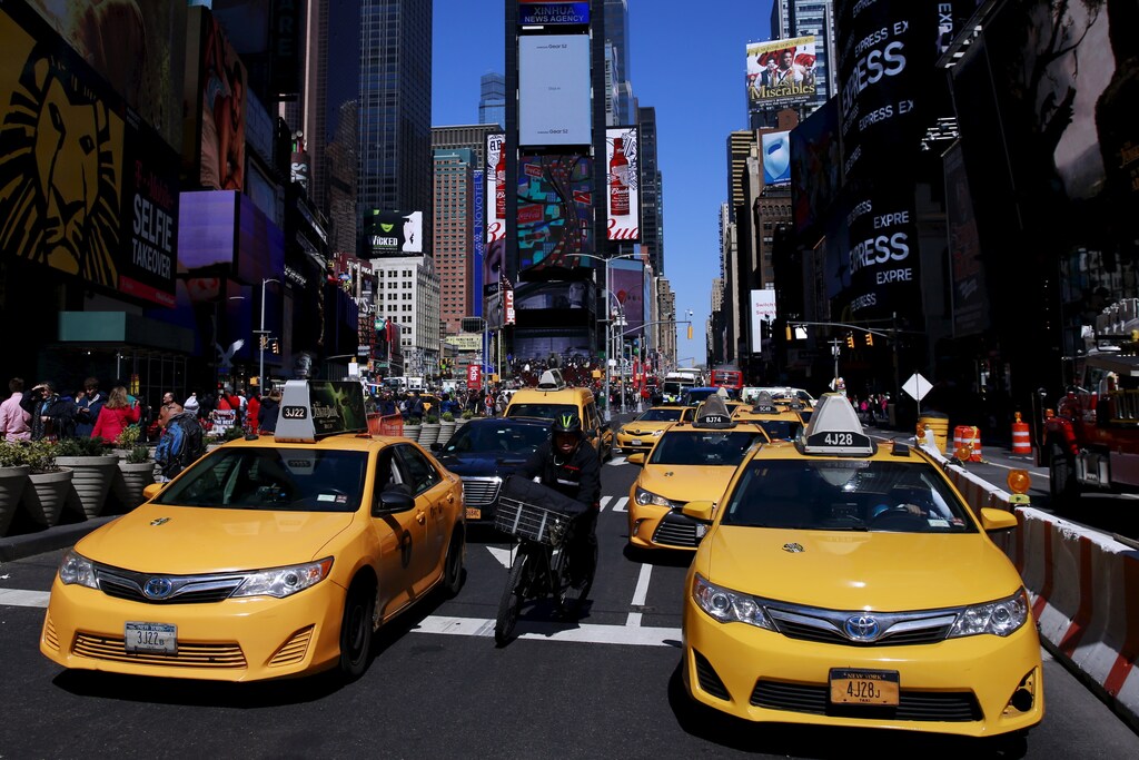 New York City taxi cabs drive through Times Square in New York March 29, 2016. REUTERS/Lucas Jackson - GF10000364442
