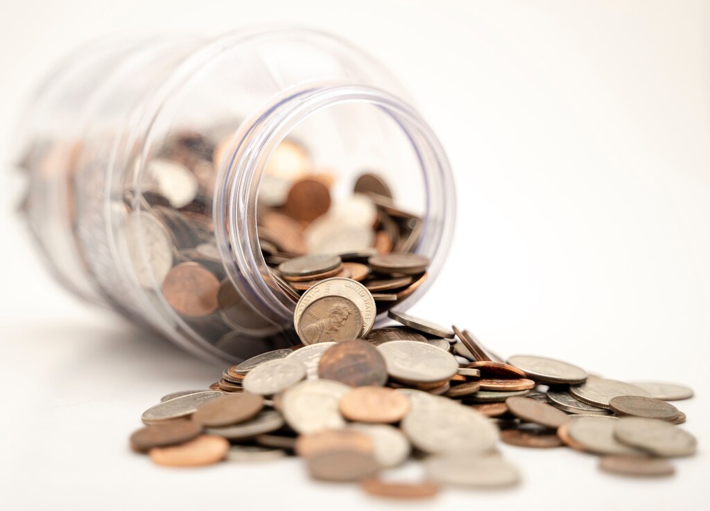 Pennies fall out of a jar.