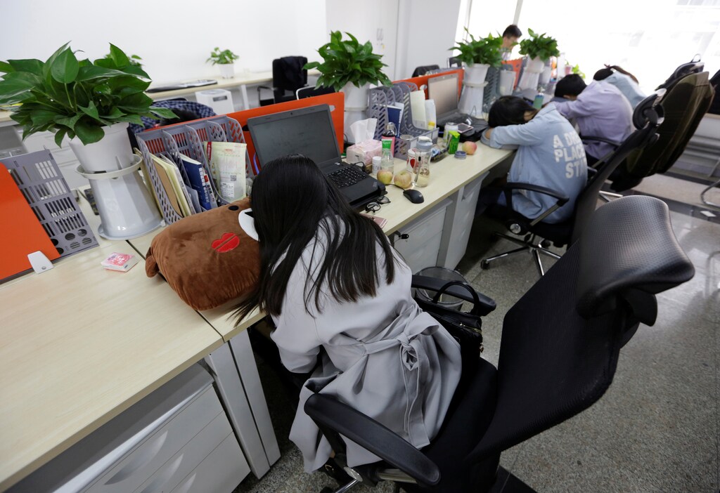 Employees at Goopal Group take a nap in their seats after lunch, in Beijing, China, April 21, 2016. Office workers sleeping on the job is a common sight in China, where a surplus of cheap labour can lead to downtime at work. But in China's technology sector, where business is growing faster than many start-up firms can hire new staff, workers burn the midnight oil to meet deadlines and compete with their rivals. Some companies provide sleeping areas and beds for workers to rest during late nights. REUTERS/Jason Lee SEARCH "JASON SLEEP" FOR THIS STORY. SEARCH "THE WIDER IMAGE" FOR ALL STORIES - RTX2DQ8X