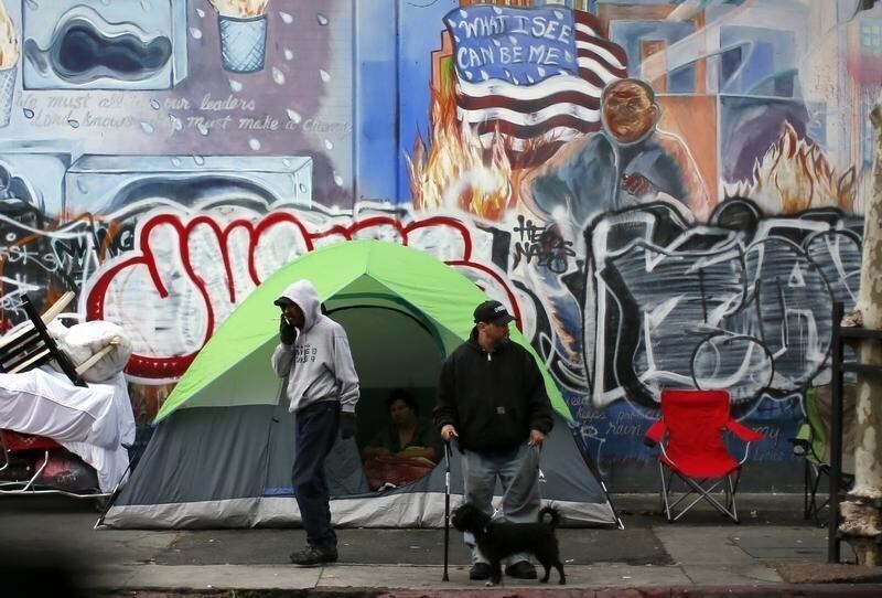 People wake up on downtown Los Angeles' Skid Row, March 7, 2013. Los Angeles has asked the U.S. Supreme Court to allow police and city workers to seize or destroy property that homeless people leave unattended on sidewalks, saying Skid Row homeless encampments presented a public-health risk. According to the Los Angeles County Department of Public Health, some 11 people have died from tuberculosis since 2007, and of the 78 people infected, 60 were homeless. REUTERS/Lucy Nicholson (UNITED STATES - Tags: POLITICS SOCIETY HEALTH POVERTY) - GM1E9380C9R01