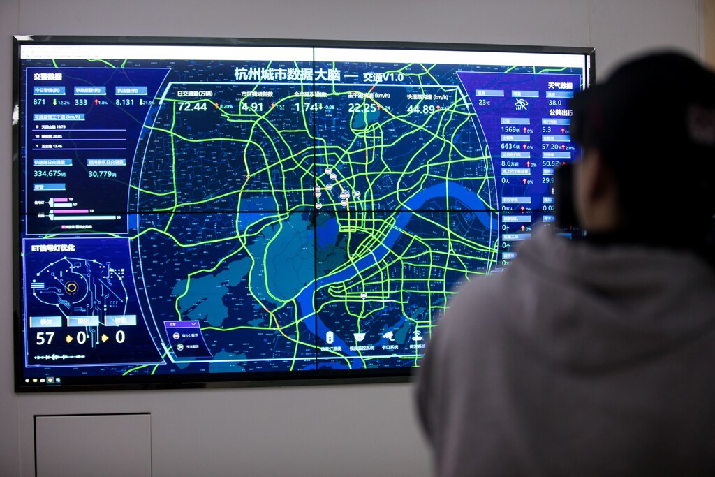 A person films a screen showing traffic data of Hangzhou city during a media tour of City Brain, an AI-powered traffic-management system by Alibaba Cloud, in Hangzhou, Zhejiang province, China April 10, 2018. Picture taken April 10, 2018. REUTERS/Stringer ATTENTION EDITORS - THIS IMAGE WAS PROVIDED BY A THIRD PARTY. CHINA OUT. - RC12EBA1B010