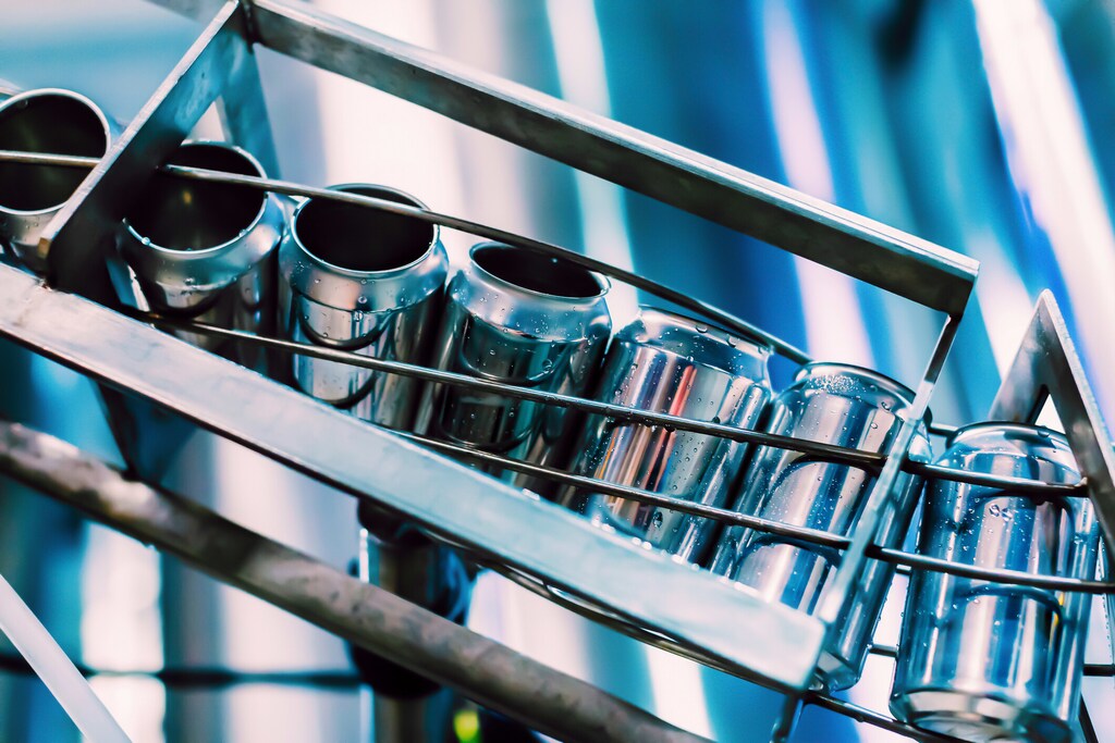 Conveyor with beer cans on the belt: The demand for aluminium is rising with net zero goals.