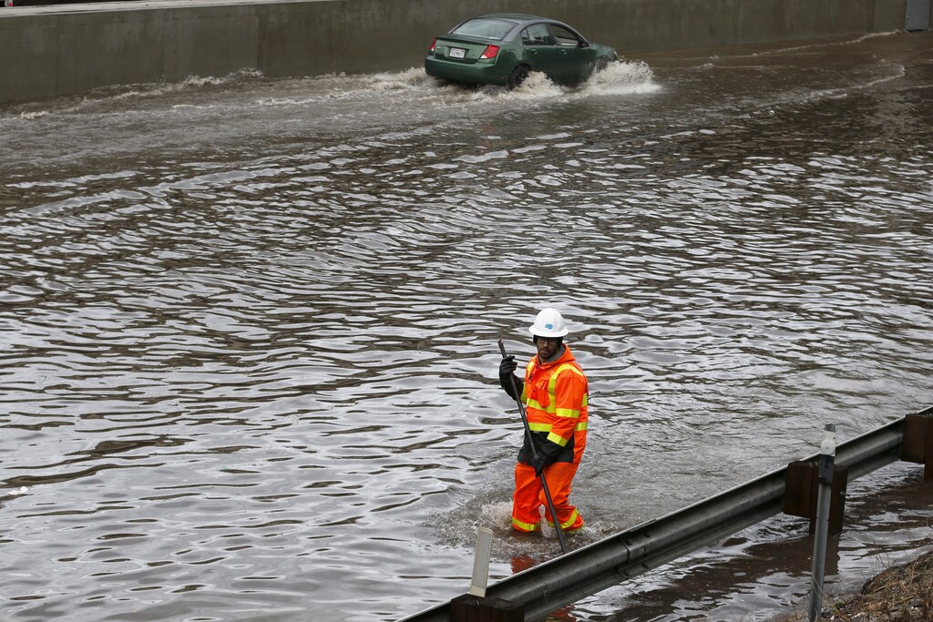 A worker wades through the flooded 5 freeway after an El Nino-strengthened storm brought rain to Los Angeles, California, United States, January 6, 2016. REUTERS/Lucy Nicholson