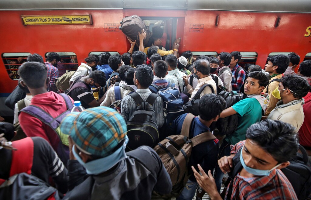 Migrant workers and their families board an overcrowded passenger train, after government imposed restrictions on public gatherings in attempts to prevent spread of coronavirus disease (COVID-19), in Mumbai, India, March 21, 2020. REUTERS/Prashant Waydande - RC28OF984OPS