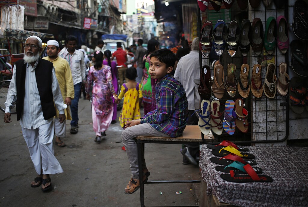 A boy calls out for customers as he sits outside a stall at a busy market place in the old quarters of Delhi March 24, 2014. REUTERS/Anindito Mukherjee (INDIA - Tags: SOCIETY) - RTR3ICVF