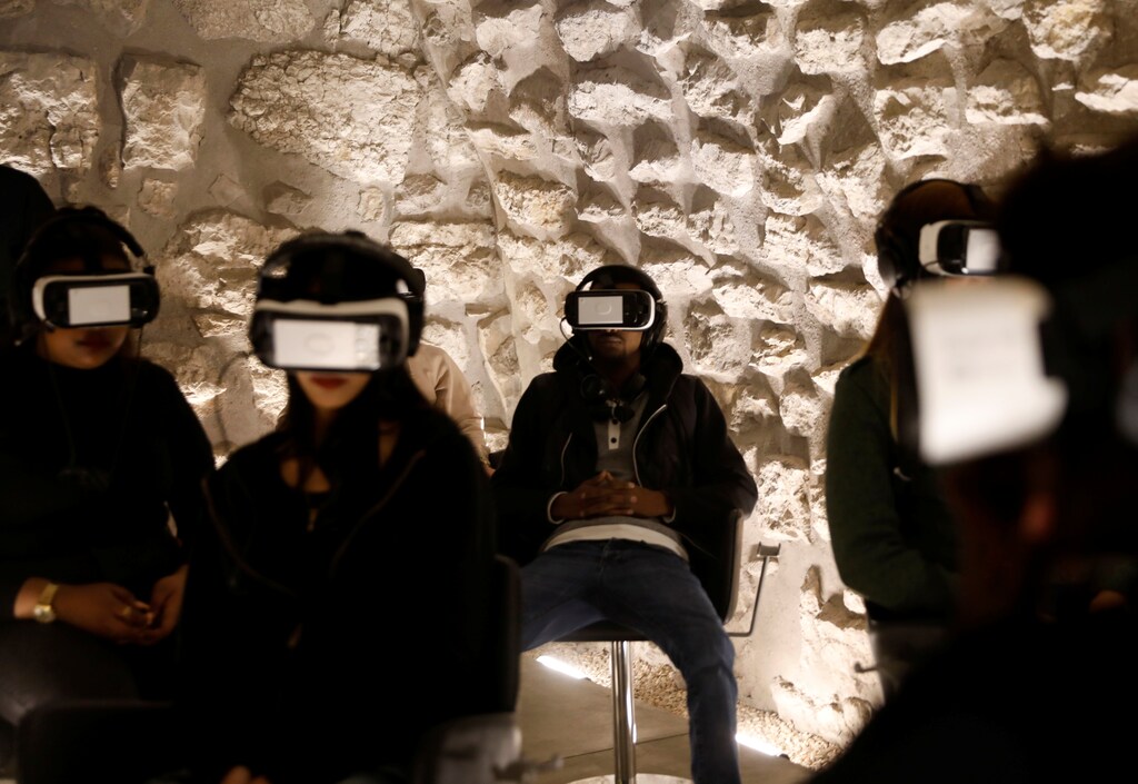 Visitors wear headsets as they experience a virtual reality tour depicting Jerusalem as it was two millennia ago, at a visitors center near some of the world's most sacred sites holy to Jews, Muslims and Christians, in Jerusalem's Old City February 20, 2017. Picture taken February 20, 2017. REUTERS/Ronen Zvulun - RTSZTCV