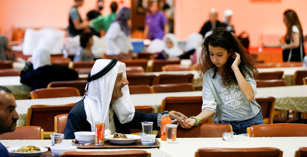A volunteers joins elderly for Iftar at an elderly care home in Amman, Jordan June 7, 2017