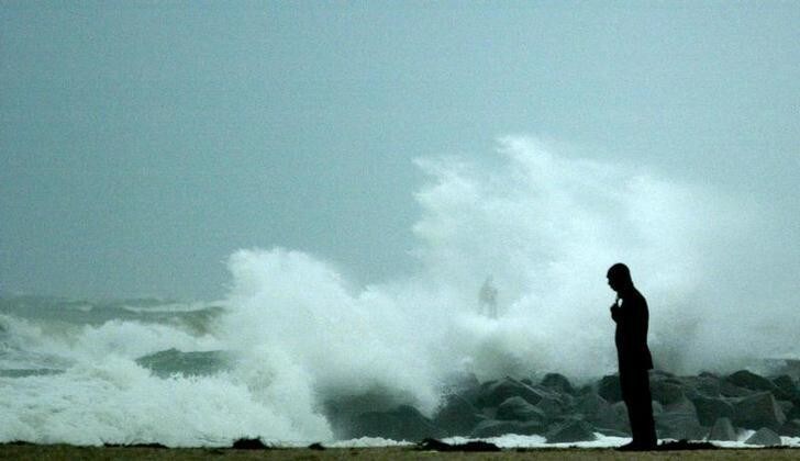 A man watches the surf as Hurricane Rita approaches Key Largo, Florida September 20, 2005. Strengthening Hurricane Rita lashed the low-lying islands of the Florida Keys with rainy squalls on Tuesday and Gulf Coast communities to the west braced for a possible encore to devastating Hurricane Katrina. REUTERS/Marc Serota MS/VP