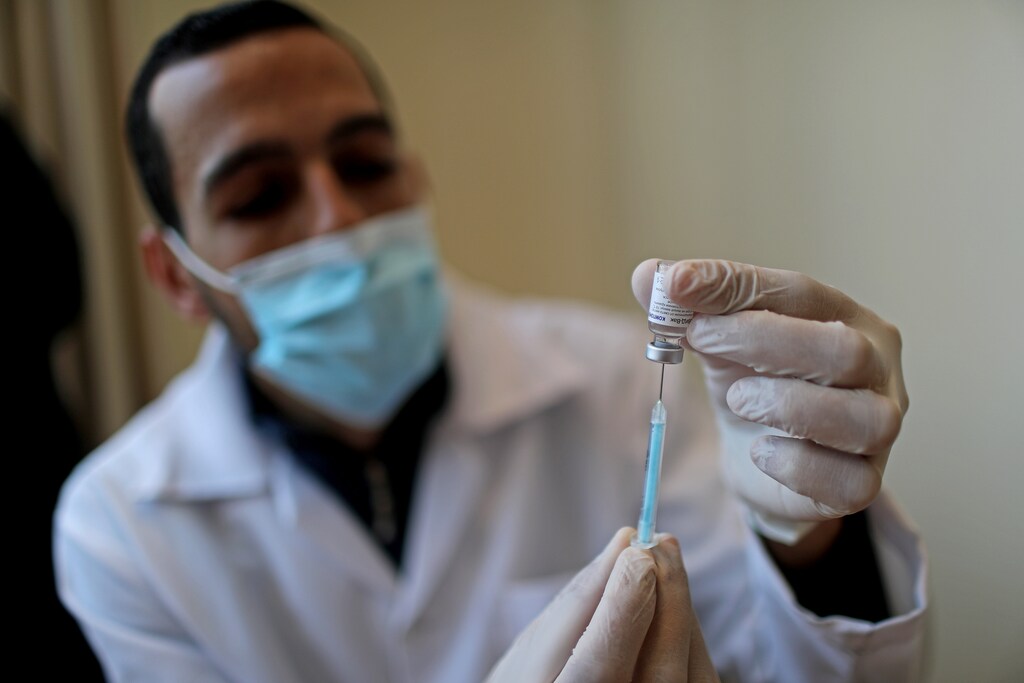 A health worker holds a vial of Russia's Sputnik V vaccine