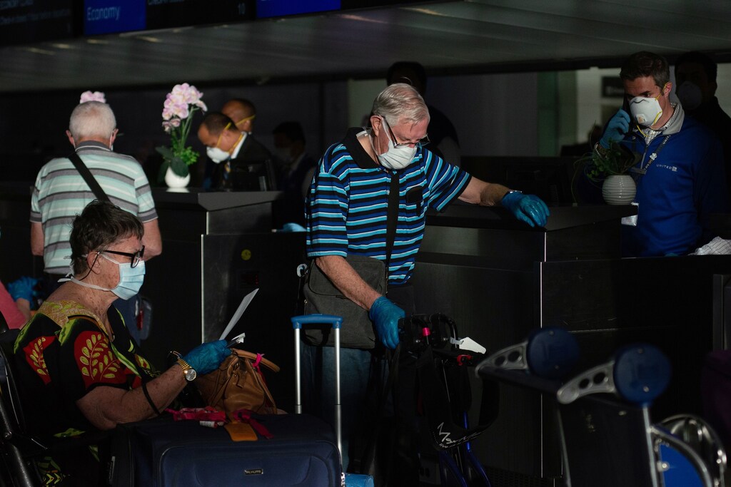 Australian citizens, who were aboard the MS Zaandam and Coral Princess cruises, now cleared to fly after quarantining, wait in line to receive their boarding passes for a specially chartered United Airlines flight to take them home to Australia at San Francisco International Airport as efforts continue to help slow the spread of coronavirus disease (COVID-19) in San Francisco, California, U.S. April 5, 2020. REUTERS/Kate Munsch - RC2SYF980GWX