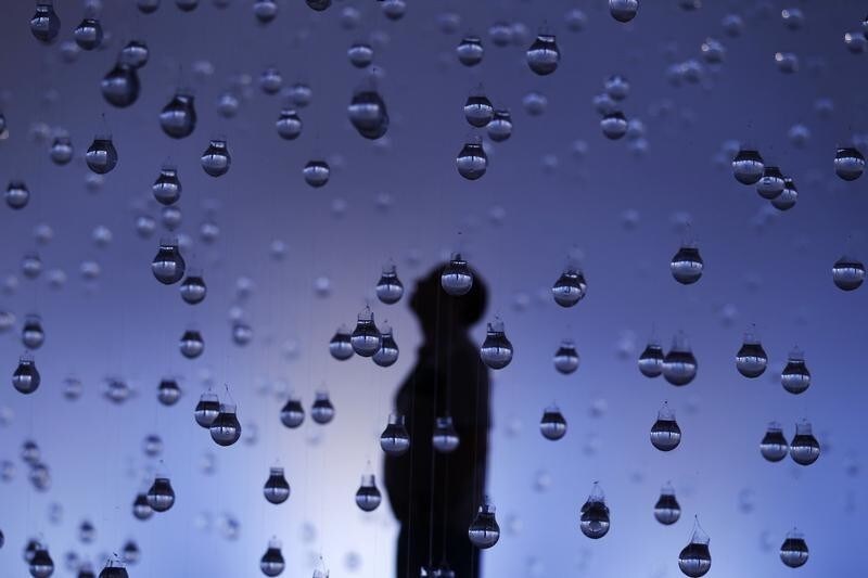 A man looks at lightbulbs filled with water as part of the exhibition "Lagrimas de Sao Pedro" (Tears of Saint Peter) by Brazilian artist Vinicius Silva, at a cultural center in Rio de Janeiro, March 21, 2013. The artist used six thousand lightbulbs to create the idea of rain, showing the relationship between peasants and rain after singing and praying for Saint Peter to cry. International Water Day is held on March 22. REUTERS/Pilar Olivares(BRAZIL - Tags: SOCIETY TPX IMAGES OF THE DAY) - RTR3FAMV