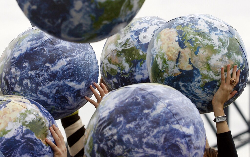 People hold up inflatable world globes during World Environment Day celebrations in central Sydney June 5, 2009. REUTERS/Daniel Munoz (AUSTRALIA ENVIRONMENT SOCIETY) - RTR24AS6