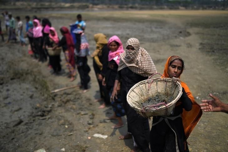 Rohingya refugee women carry baskets of dried out mud from the riverbed to help raise the ground level of the camp in preparation for monsoon season, in Shamlapur refugee camp in Cox's Bazaar, Bangladesh, March 24, 2018. REUTERS/Clodagh Kilcoyne SEARCH "KILCOYNE FISHING" FOR THIS STORY. SEARCH "WIDER IMAGE" FOR ALL STORIES.