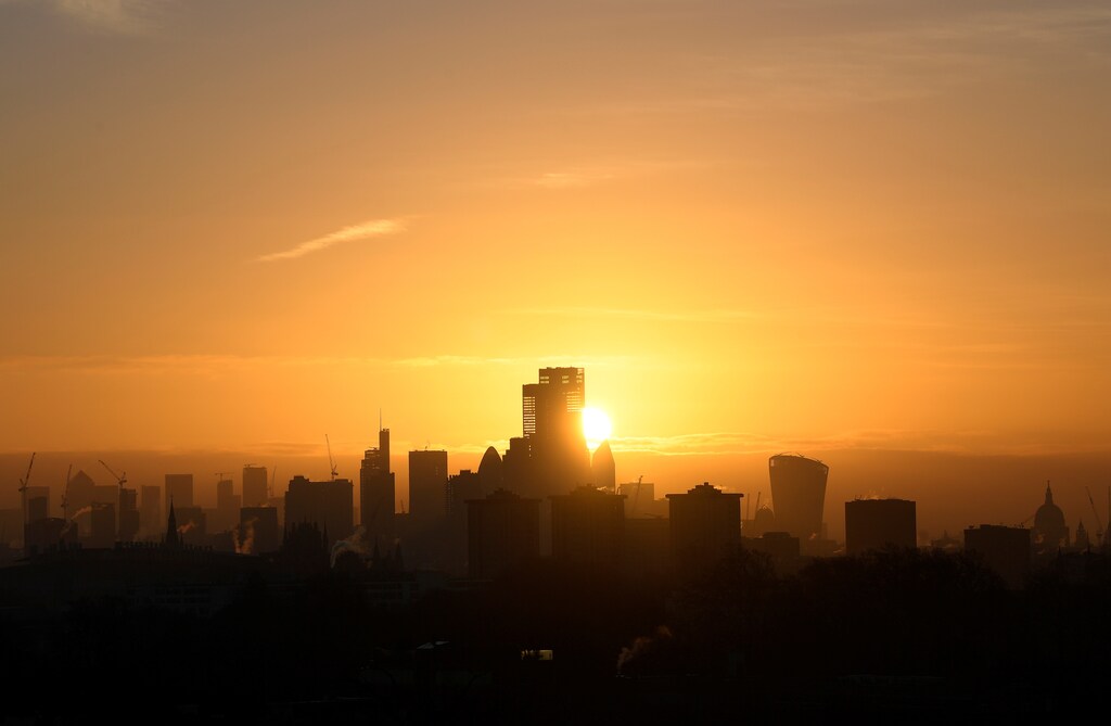 The sun is seen rising behind skyscrapers and buildings in in the City of London financial district, London, Britain, February 5, 2020.