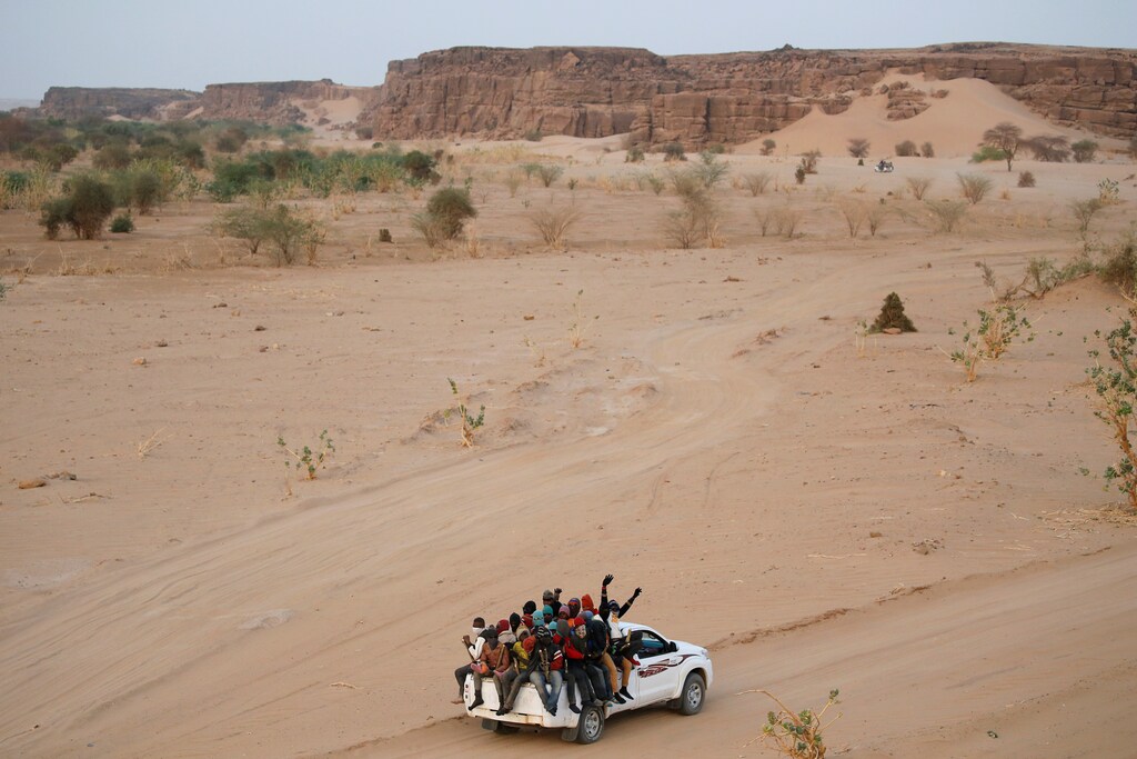 Los migrantes que cruzan el desierto del Sahara hacia Libia viajan en la parte trasera de una camioneta en las afueras de Agadez, Níger, el 9 de mayo de 2016.