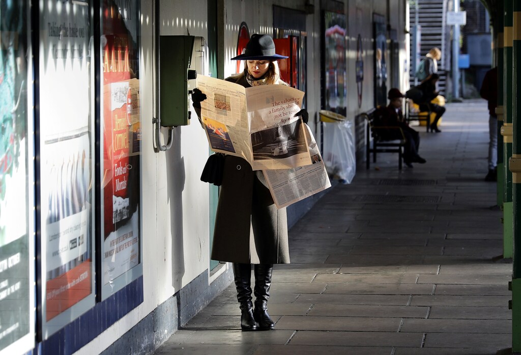 A woman reads a newspaper whilst waiting for a tube train on an autumn morning in London, Britain, October 30, 2017. REUTERS/Kevin Coombs - RC14C0007EA0