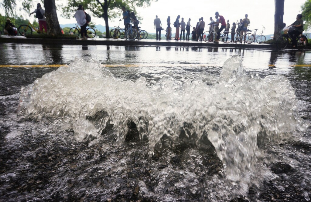 Water gushes out of a manhole as a street is flooded after heavy rain in Hangzhou, Zhejiang province, China June 24, 2017. Picture taken June 24, 2017. REUTERS/Stringer ATTENTION EDITORS - THIS IMAGE WAS PROVIDED BY A THIRD PARTY. CHINA OUT. NO COMMERCIAL OR EDITORIAL SALES IN CHINA. - RTS18IY7