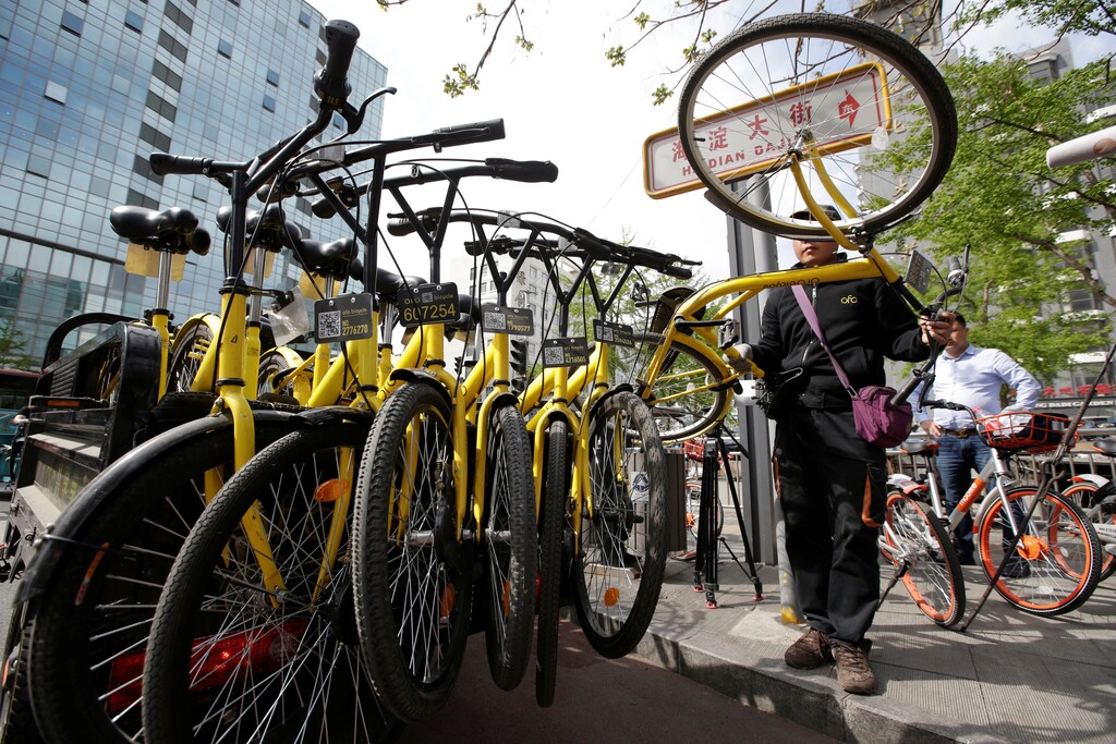 A staff member from the bike-sharing company Ofo gathers its shared bikes for use during the evening rush hour, in Beijing, China April 12, 2017. Picture taken April 12, 2017. REUTERS/Jason Lee - RTS16B7J