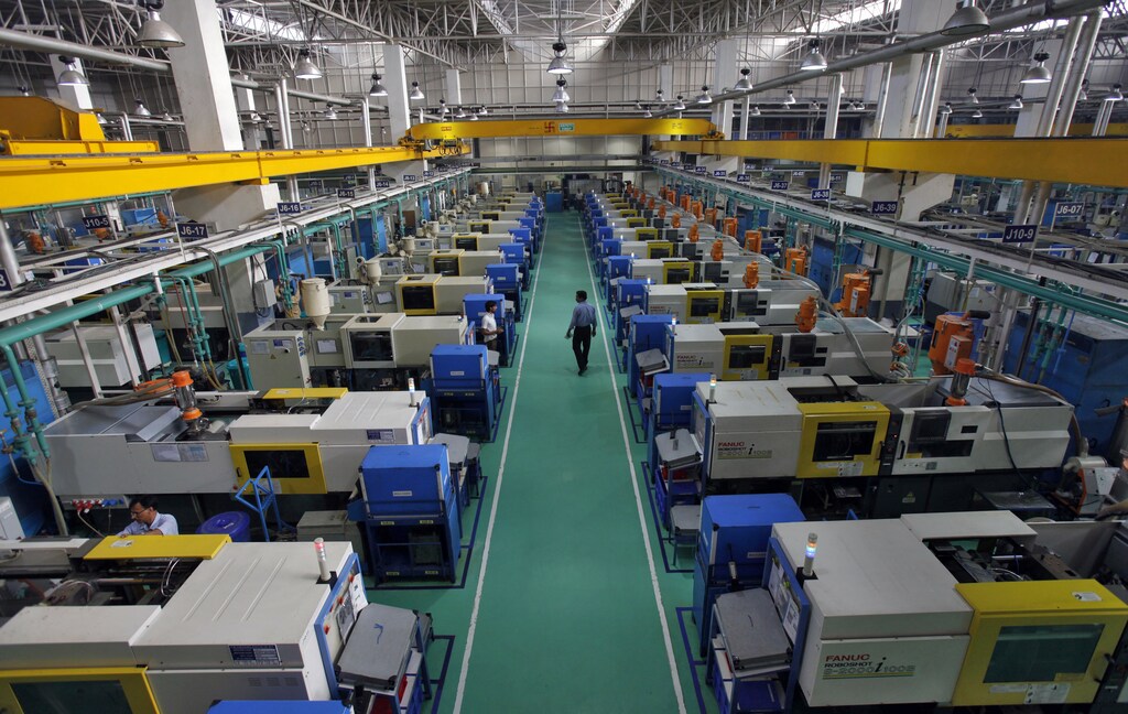 Employees work on machines used to make auto parts at the factory of the Samvardhana Motherson Group, an auto components making company, in Noida May 5, 2011. Large local auto parts makers are forming joint ventures to boost their technological know-how and expand product range as the largely fragmented sector is at full capacity and facing a capital crunch. Picture taken May 5, 2011. REUTERS/Adnan Abidi (INDIA - Tags: TRANSPORT BUSINESS EMPLOYMENT SCI TECH) - GM1E75N1EP301