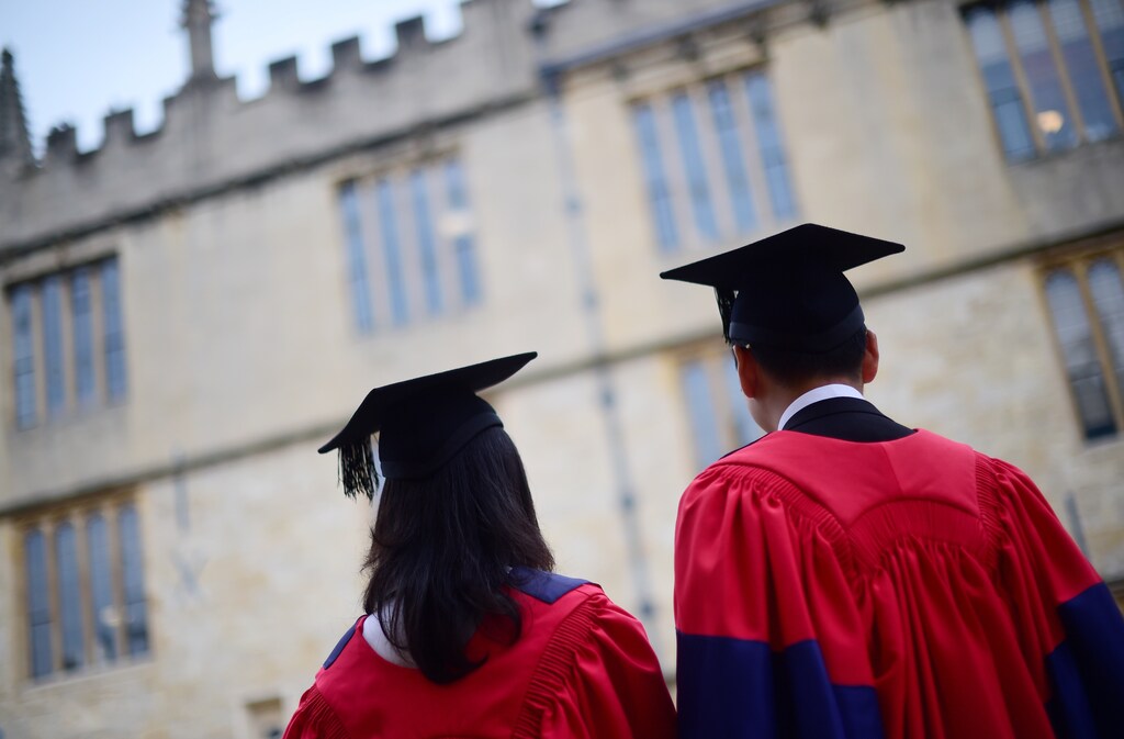 Graduates gather outside the Sheldonian Theatre after a graduation ceremony at Oxford University, in Oxford, Britain July 15, 2017. REUTERS/Hannah McKay - RC1FA0E0EF00