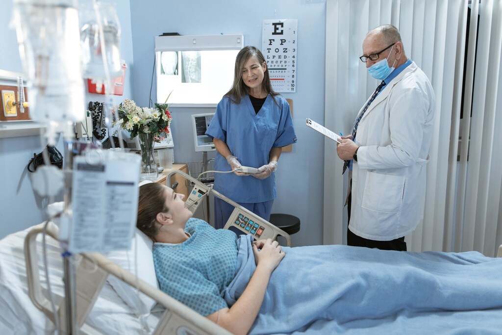 A patient receiving healthcare from a nurse and a doctor.
