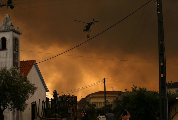 A fire fighting helicopter works to contain a wildfire in Leiria, Portugal July 13, 2022.