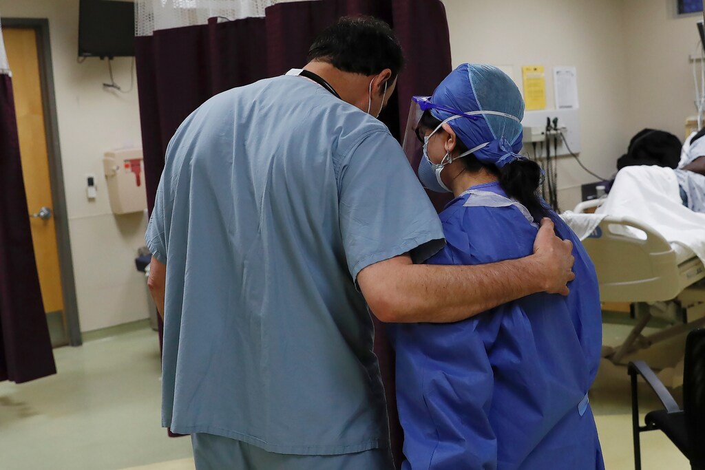 A doctor embraces a colleague as the spread of the coronavirus disease (COVID-19) continues, in the emergency room at Roseland Community Hospital on the South Side of Chicago, Illinois, U.S., April 22, 2020. REUTERS/Shannon Stapleton - RC2Z9G9NSC7D