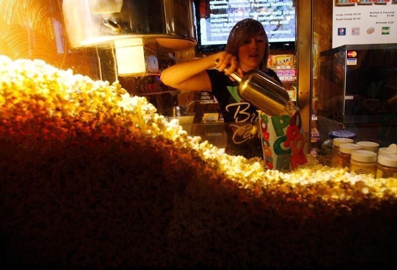 Cailynn Williams, 17, fills a bag of popcorn for a customer at the New Strand Theater in West Liberty, Iowa July 8, 2011. Todd Leach, who owns the New Strand Theater, says that ticket sales are down from last summer due to the economy. Voters in the Iowa caucus and the New Hampshire primary will be the first to cast ballots in the upcoming U.S. Presidential race. REUTERS/Jessica Rinaldi (UNITED STATES - Tags: POLITICS SOCIETY) - RTR2ONFS