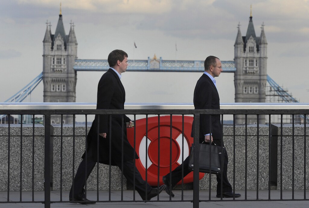 City workers pass a life-buoy on London Bridge during the evening rush-hour in the City of London.