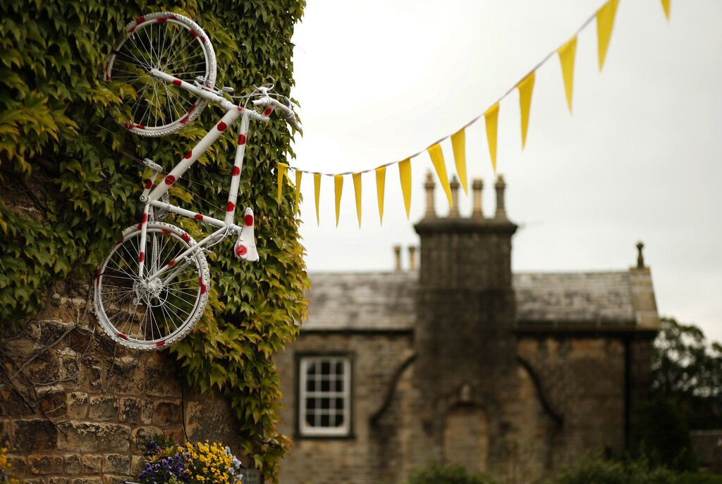 A bicycle decorated with polka dots hangs from the wall of a pub on the route of the Tour de France in Addingham, northern England June 17, 2014. Tour de France fever has hit the Yorkshire Dales, with yellow bicycles appearing in hedgerows, outside pubs and in people's front gardens. The county will host the start of this year's Tour de France and as the excitement builds, bicycle-themed decorations adorn the countryside. Picture taken June 17, 2014. REUTERS/Phil Noble (BRITAIN - Tags: SPORT SOCCER SOCIETY)