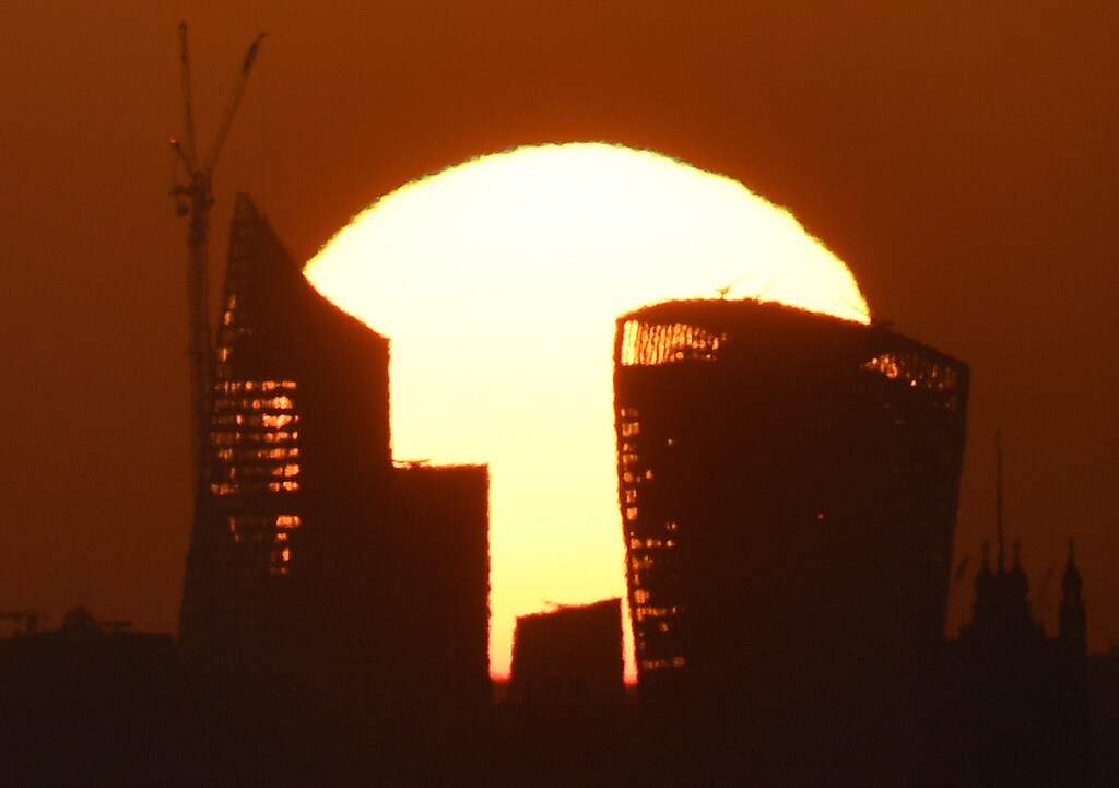 The sun is seen rising over skyscrapers in the City of London financial district in London, Britain, May 3, 2018.