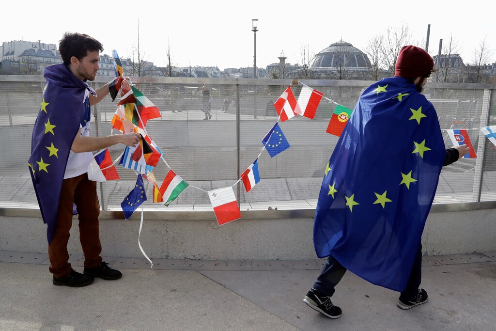 People from a pro EU group called Pulse of Europe remove flags after a small gathering in Paris, France March 12, 2017. REUTERS/Kevin Coombs - RTX30OUR
