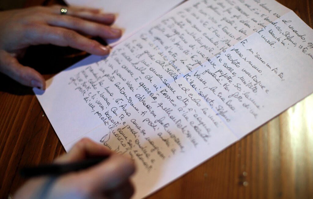 Domitilla Stefanini writes a love letter dictated by ghostwriter Micol Graziano, not seen, in Rome, Italy, March 19, 2018. Picture taken March 19, 2018. REUTERS/Max Rossi - RC1D0CC9D230