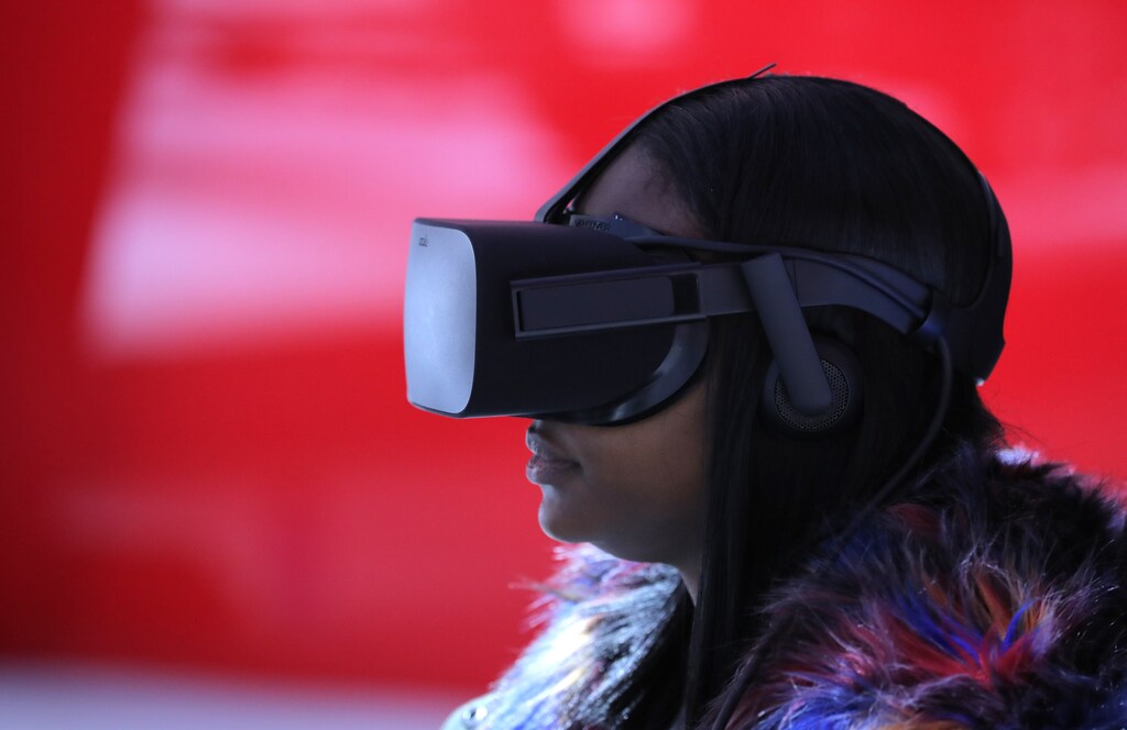 A woman wears VR goggles as she sits in a virtual reality booth at the North American International Auto Show in Detroit, Michigan, U.S., January 15, 2019. REUTERS/Brendan McDermid
